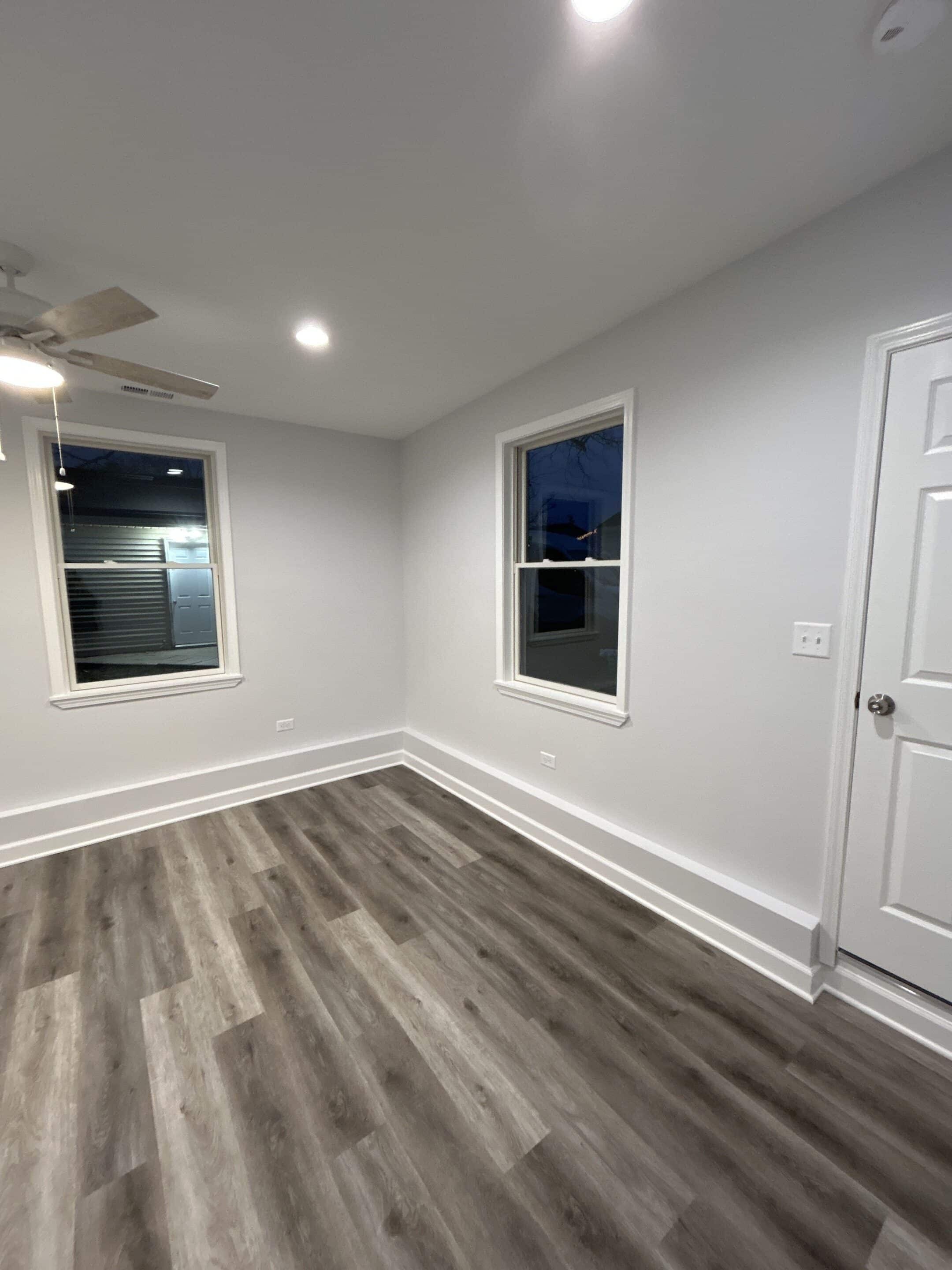 Finished lower-level room with recessed lighting and plank flooring